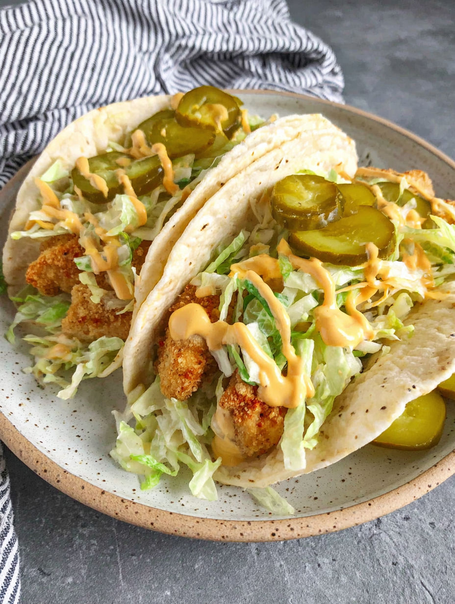A plate of food with lettuce and pickles on top.