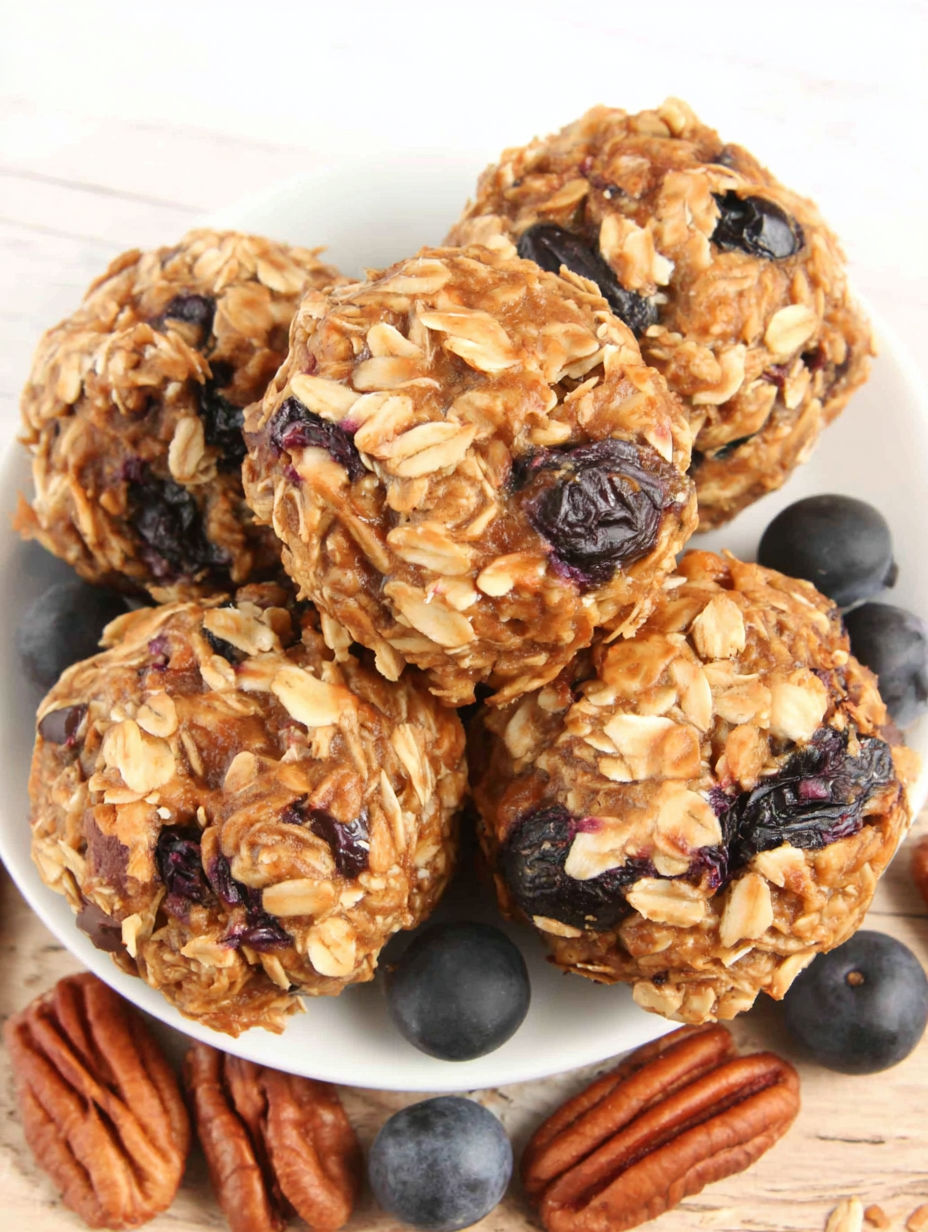 A plate of oatmeal cookies with blueberries on top.