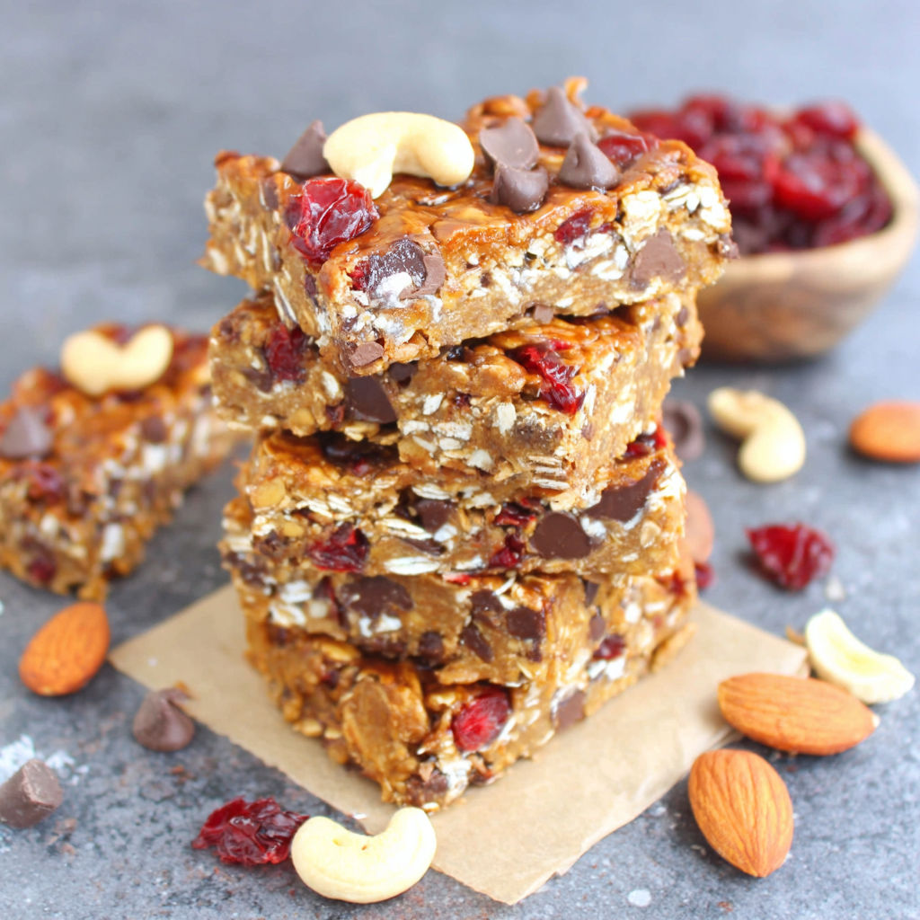 Three stacked bars of granola with chocolate chips and nuts.