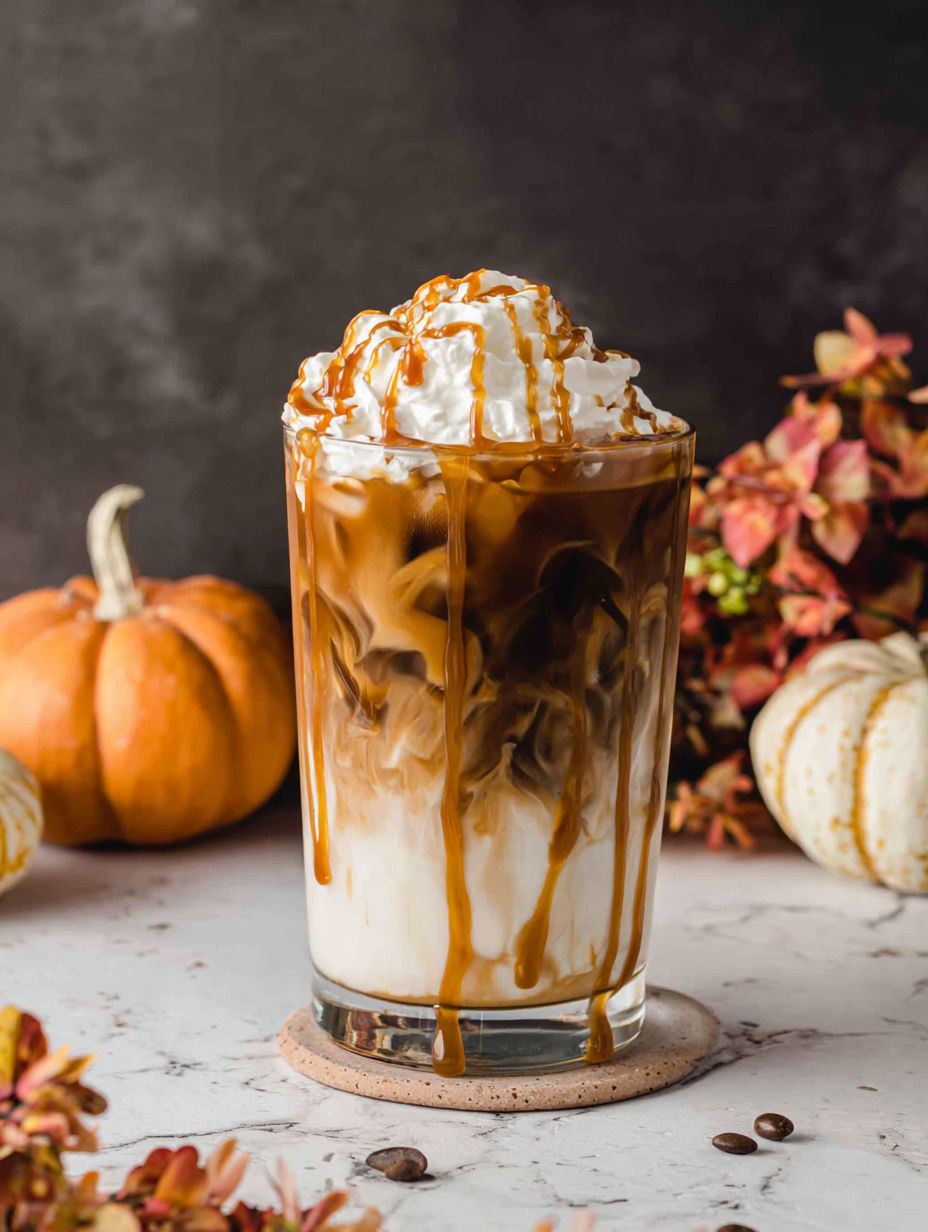 A glass of coffee with whipped cream on top.