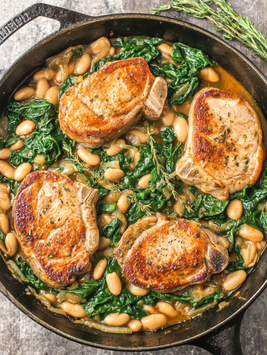 A skillet dinner with pork chops, white beans, and spinach.