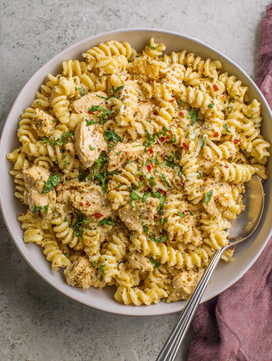 A bowl of pasta with chicken and garlic.