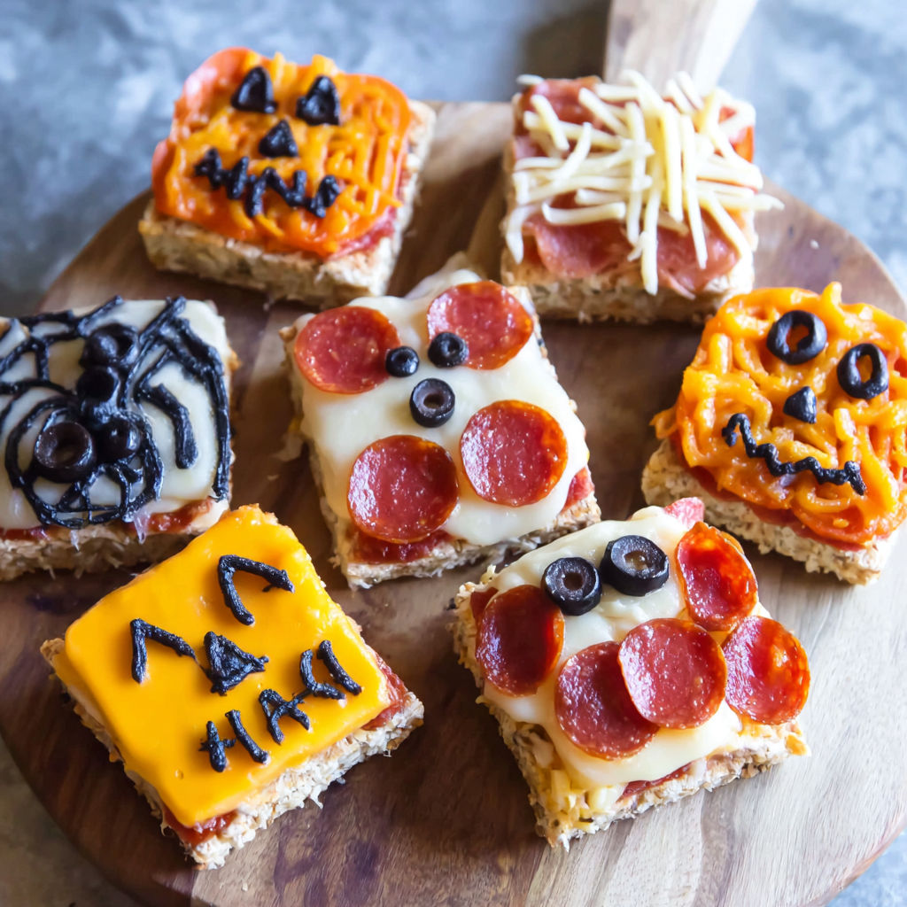 Halloween party pizzas on a wooden platter.