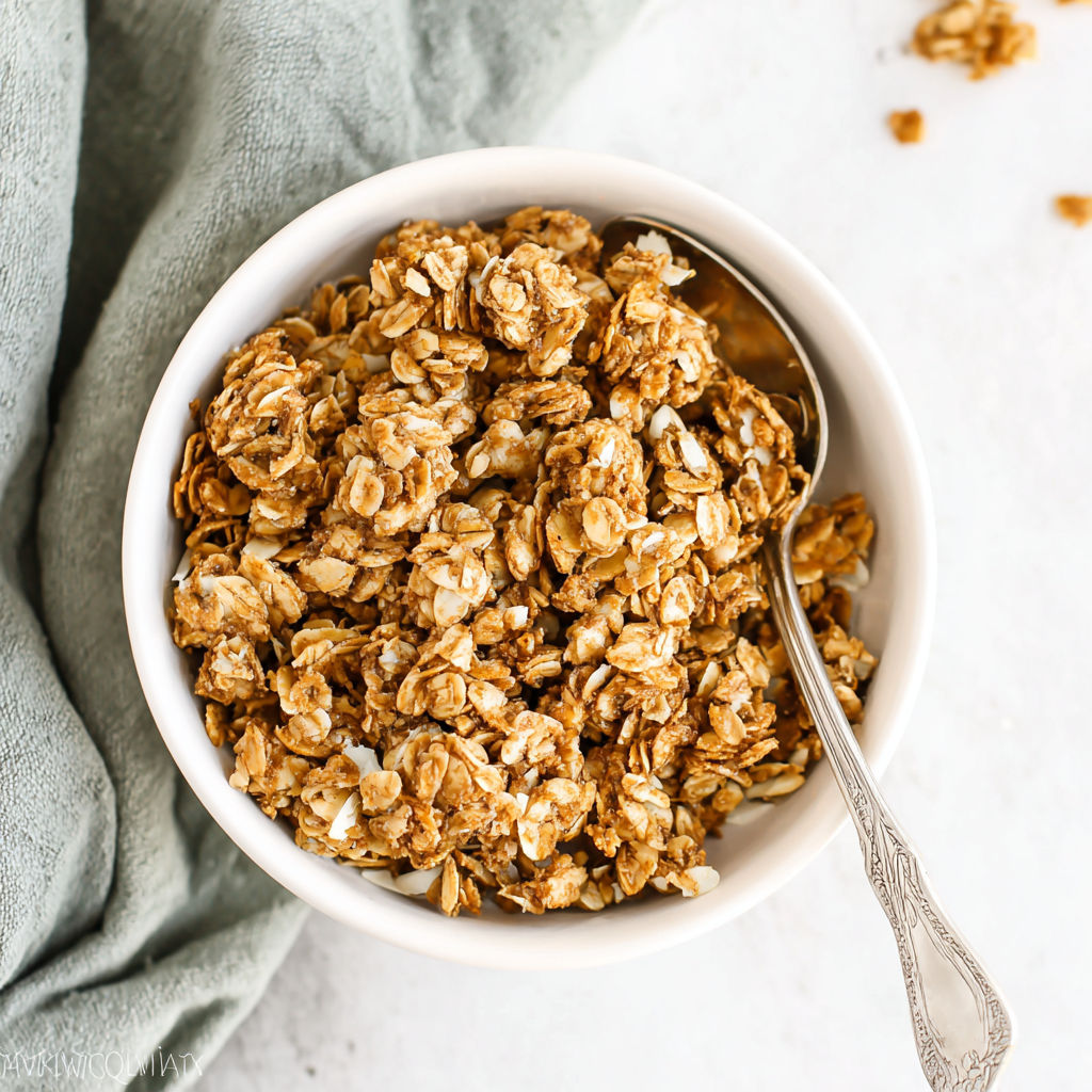 A bowl of granola with a spoon in it.