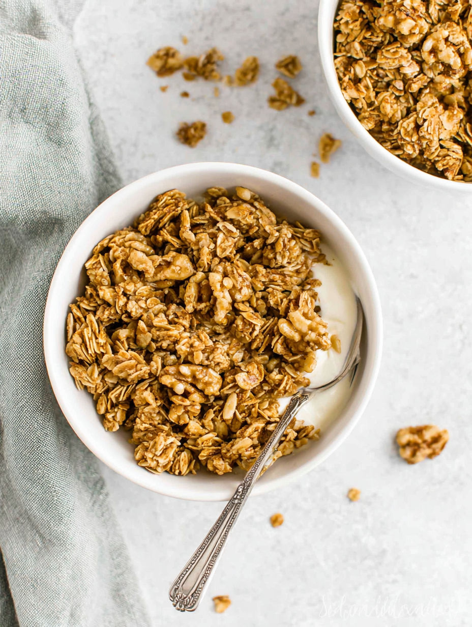 A bowl of granola with a spoon in it.