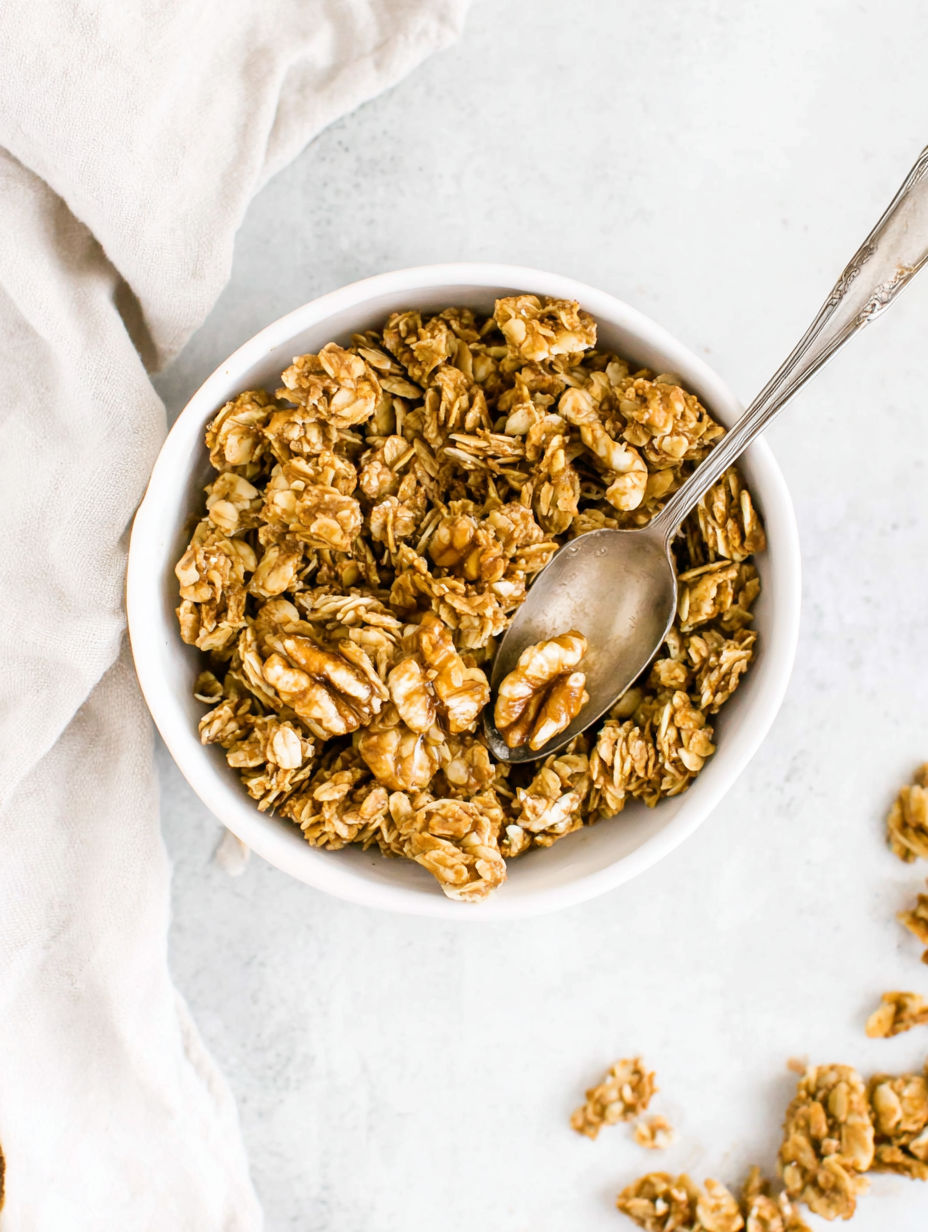 A bowl of granola with a spoon in it.