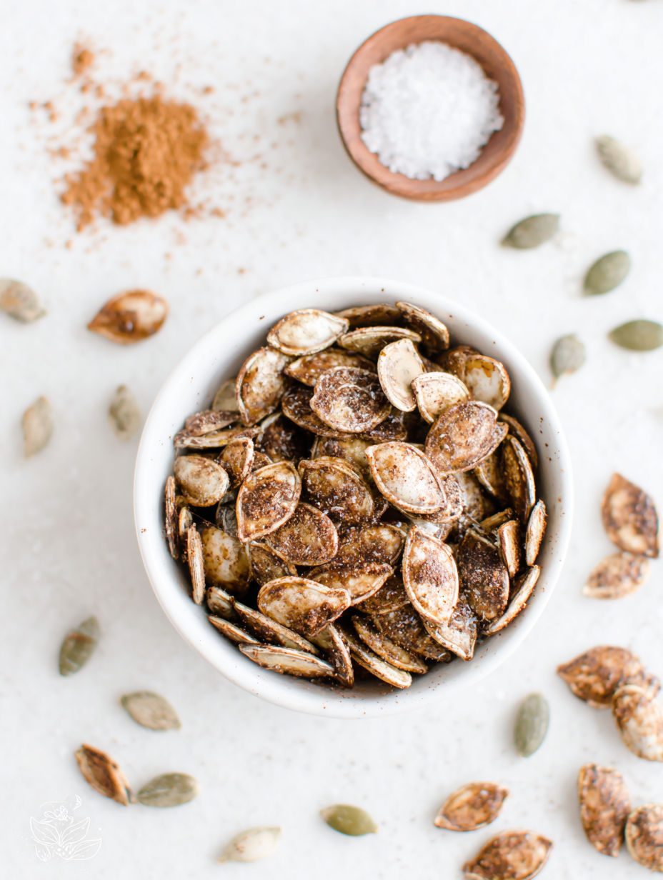 A bowl of pumpkin seeds with a spoon in it.