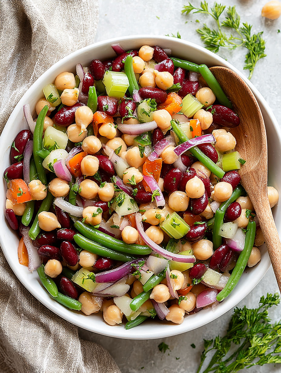A bowl of food with chickpeas, onions, and red beans.
