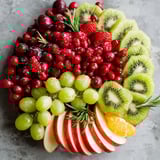 A fruit platter with grapes, kiwi, and other fruits.