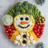 A snowman made of vegetables and two dips.