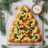 A veggie pizza shaped like a Christmas tree.