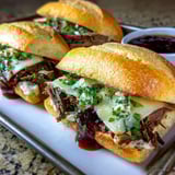 A close up of a sandwich with meat and cheese.