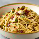 A bowl of chicken and bacon pasta.