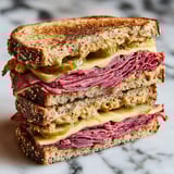 A stack of pastrami sandwiches on rye.