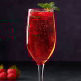 A glass of red drink with a strawberry on top.