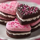 A plate of heart shaped cookies with pink frosting.