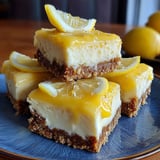 A stack of three lemon curd cheesecake bars.