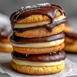 A stack of cookies with chocolate icing.