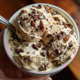 A person holding a bowl of yogurt cookie dough.