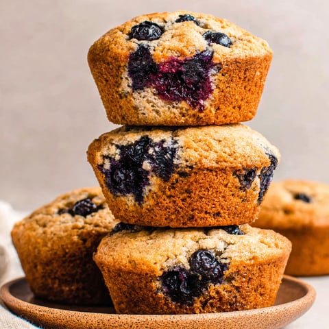 Three stacks of blueberry muffins on a plate.
