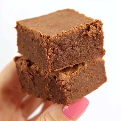 A person holding a piece of chocolate cake.