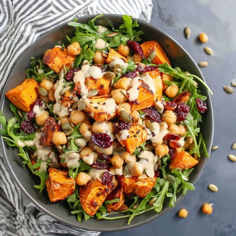 A bowl of roasted chickpea and sweet potato salad with sweet tahini dressing.