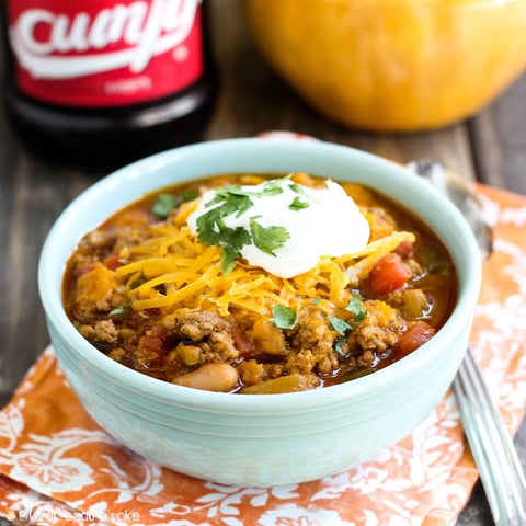 A bowl of chili with a spoon in it.