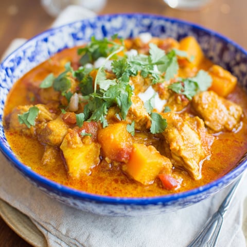 A bowl of chicken and butternut squash curry.