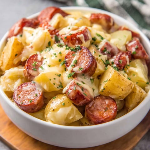A bowl of potatoes and sausage.