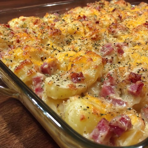A cheesy ham potato casserole in a glass dish.