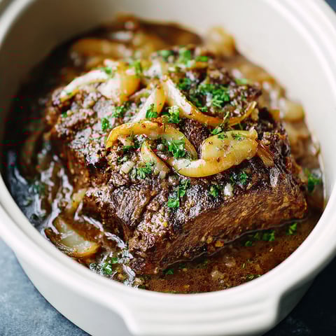 A pot of beef in a crockpot with onions.