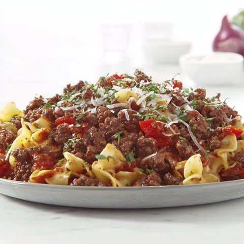 A plate of meat with cheese and peppers.