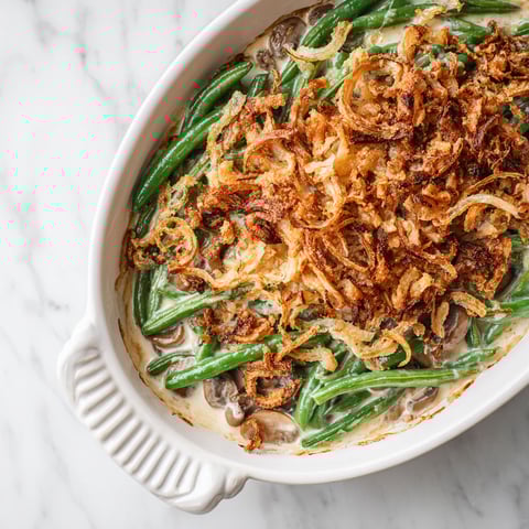 A white bowl filled with a green bean casserole.
