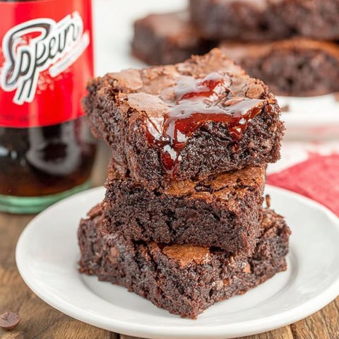 A stack of brownies with a Dr Pepper soda.