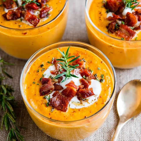 Three bowls of soup with bacon and chorizo.