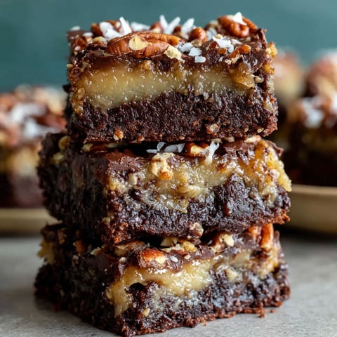 German chocolate pecan brownies stacked on a table.