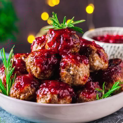 A bowl of meatballs with cranberry sauce.