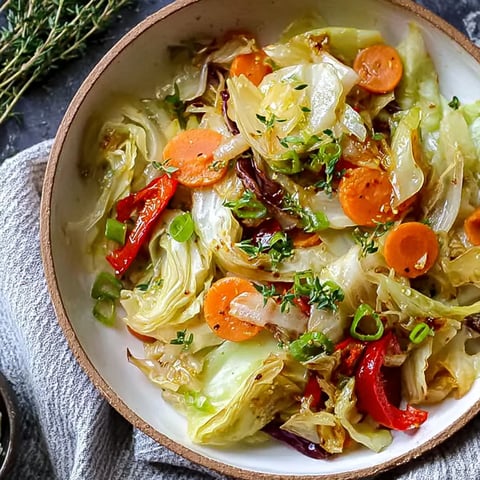 A bowl of vegetables including cabbage, carrots, and peppers.
